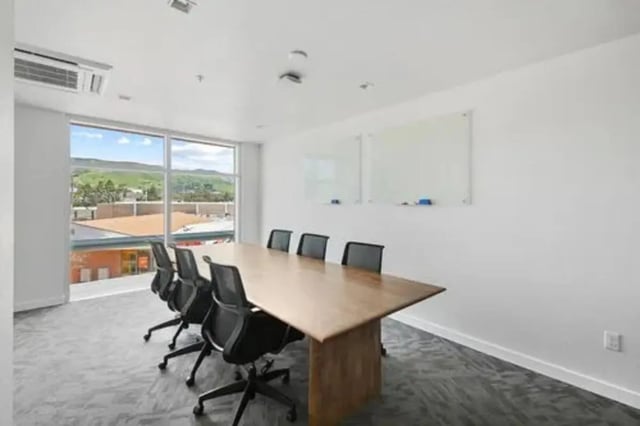 Conference table with chairs and whiteboards meeting room at Summit SLO in San Luis Obispo Student Accommodation