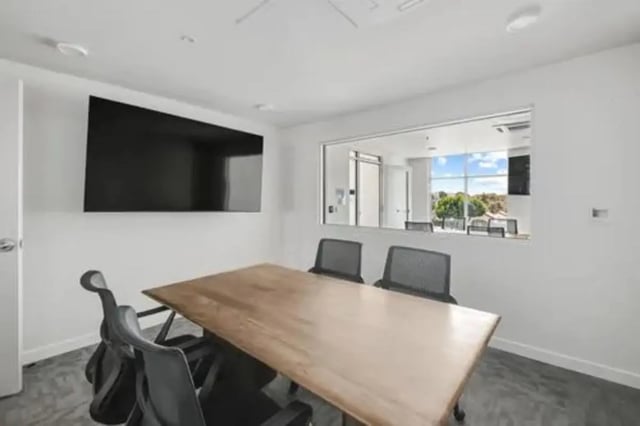 Conference table and chairs with a large screen meeting room at Summit SLO in San Luis Obispo Student Accommodation