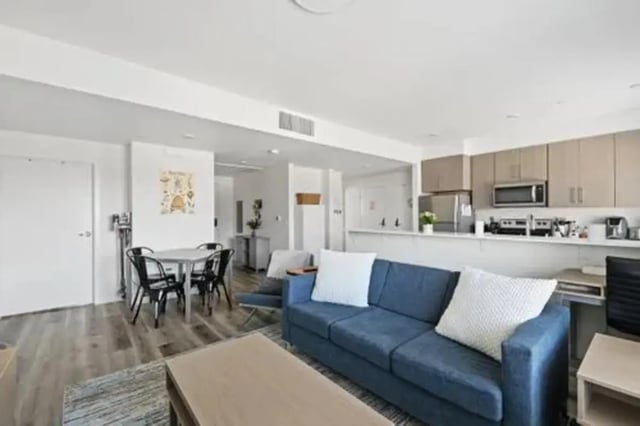 Blue sofa dining table and kitchen living room at Summit SLO in San Luis Obispo Student Accommodation