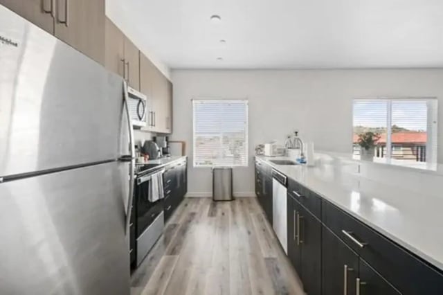 Stainless steel refrigerator dark cabinets modern kitchen kitchen at Summit SLO in San Luis Obispo Student Accommodation