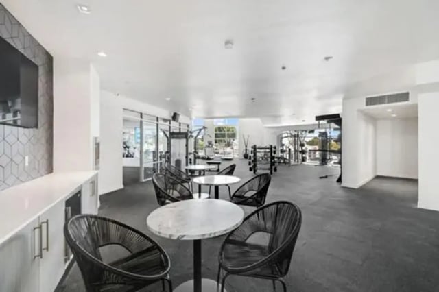 Tables chairs gym equipment lounge area gym at Summit SLO in San Luis Obispo Student Accommodation