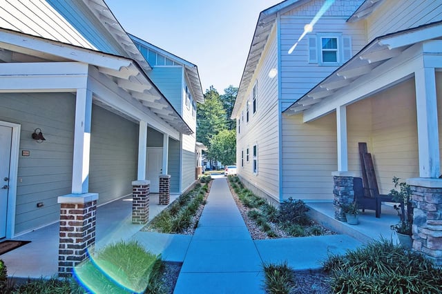 Townhouses with covered porches and manicured landscaping exterior at The Towns at Octiv Row in Carrollton Student Accommodation