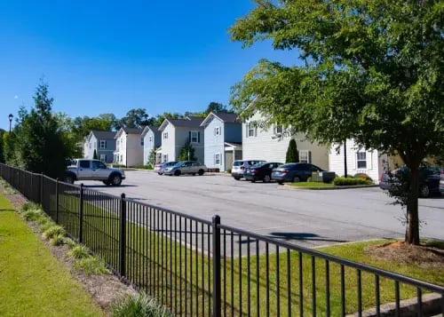 Apartment buildings with parked cars exterior at The Towns at Octiv Row in Carrollton Student Accommodation