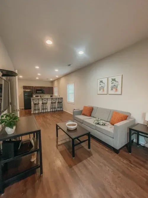 Sofa kitchen island and stools living room at The Towns at Octiv Row in Carrollton Student Accommodation