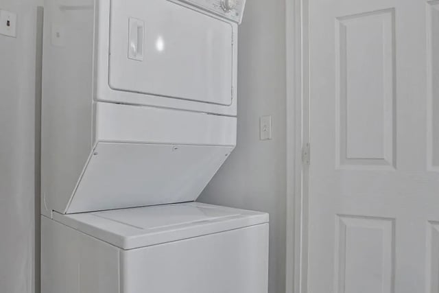 Stacked white washer dryer next to door utility area at Mazza GrandMarc in College Park Student Accommodation