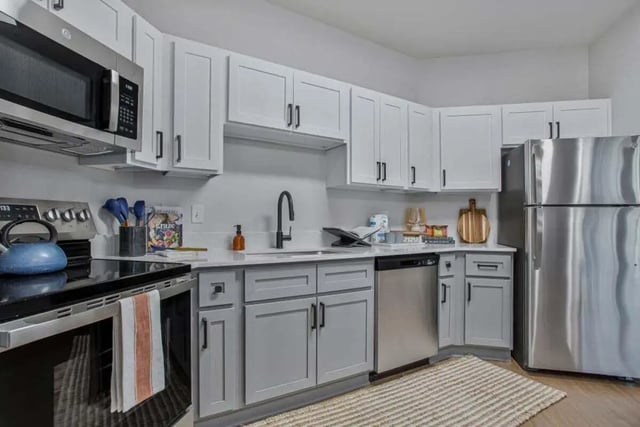 Stainless steel refrigerator white cabinets and stove kitchen at Mazza GrandMarc in College Park Student Accommodation