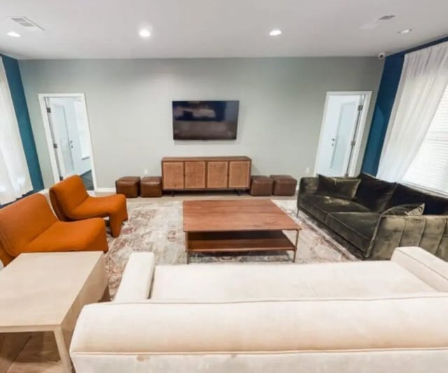 Orange chairs dark sofa coffee table living room at The Hamptons Statesboro in Statesboro Student Accommodation