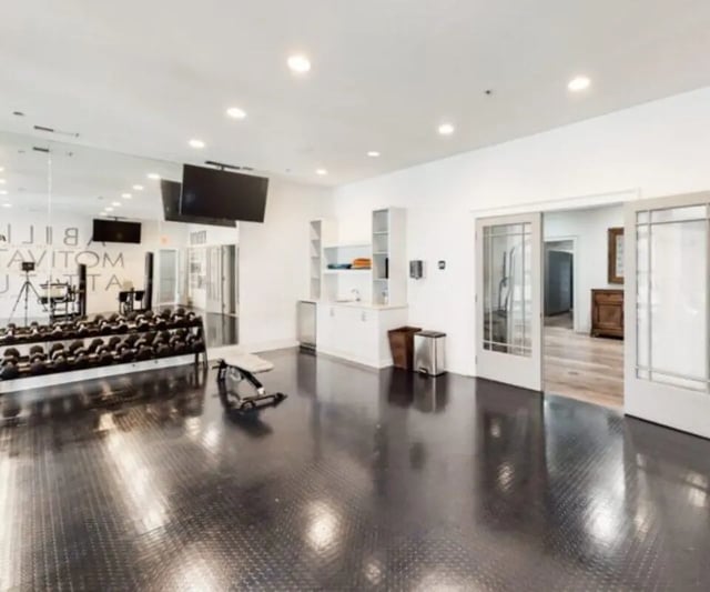 Dumbbell rack bench and TVs gym at The Hamptons Statesboro in Statesboro Student Accommodation