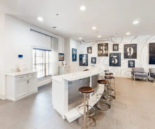 Bar stools at counter with framed numbers wall living room at The Hamptons Statesboro in Statesboro Student Accommodation