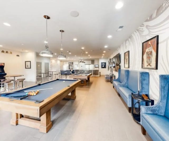 Pool tables arcade game and blue seating lounge area at The Hamptons Statesboro in Statesboro Student Accommodation