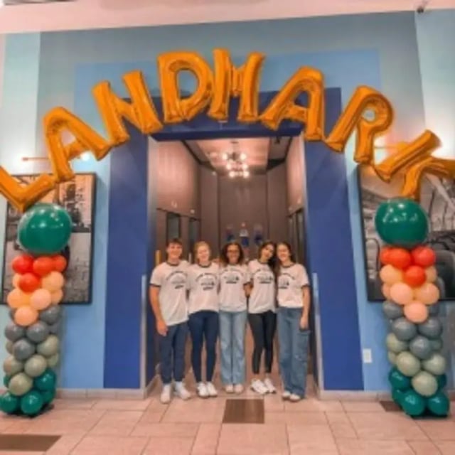 Group of students standing under balloons entryway exterior at Landmark Apartments in Ann Arbor Student Accommodation