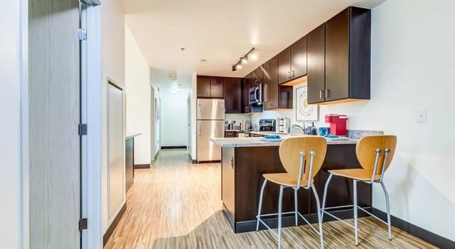 Counter with stools stainless steel refrigerator kitchen at Landmark Apartments in Ann Arbor Student Accommodation