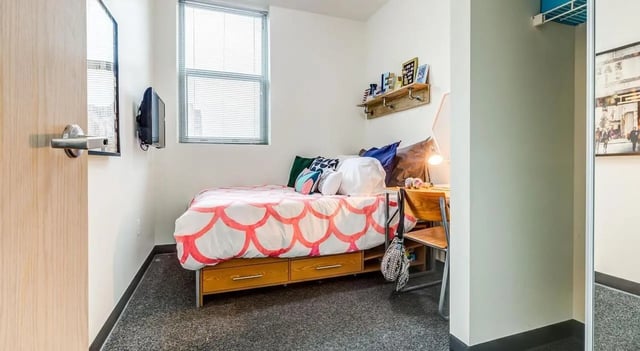 Bed desk wall mounted tv and shelves bedroom at Landmark Apartments in Ann Arbor Student Accommodation