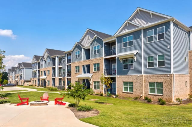 Apartment buildings with red chairs and fire pit exterior at Stadium View in Ames Student Accommodation