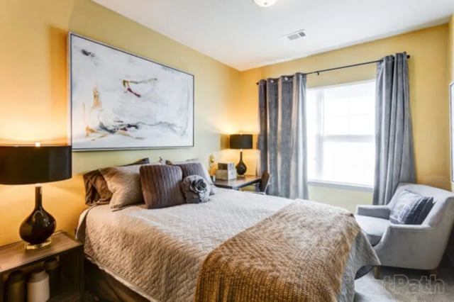 Bed with art desk lamp armchair window bedroom at Stadium View in Ames Student Accommodation