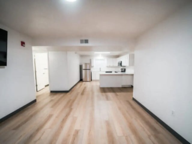 Modern kitchen and living area with wood floors at Village on the Parkway in Orem Student Accommodation