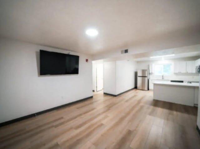 Wall mounted TV stainless steel refrigerator kitchen island living room kitchen at Village on the Parkway in Orem Student Accommodation