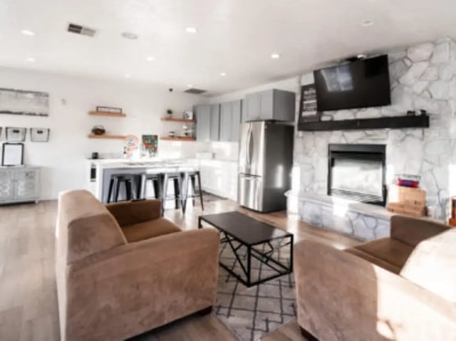 Sofa kitchen island fireplace TV living room at Village on the Parkway in Orem Student Accommodation