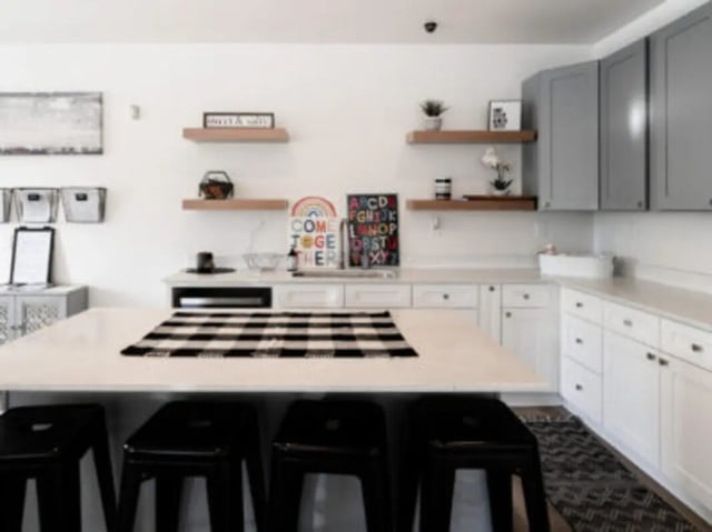 Kitchen island with black stools white cabinets kitchen at Village on the Parkway in Orem Student Accommodation