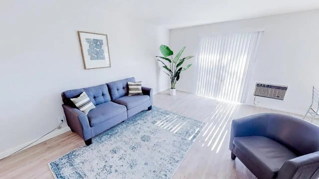 Blue sofa rug art plant air conditioner living room at Wildcat Crossing in Chico Student Accommodation