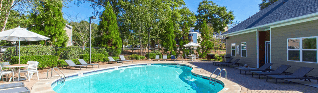 Pool loungers tables umbrellas and fencing outdoor area exterior at Landmark Athens in Athens Student Accommodation
