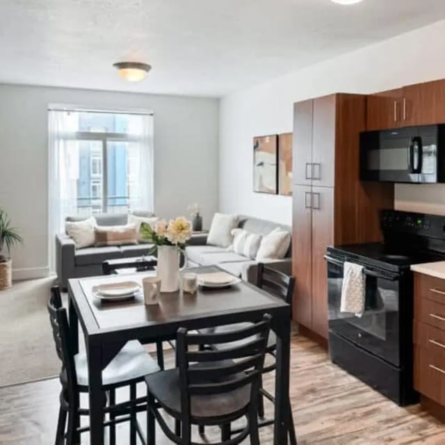Dining table chairs sofa stove kitchen living room at Promenade Place in Orem Student Accommodation