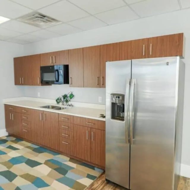 Wood cabinets microwave double sink stainless steel refrigerator kitchen at Promenade Place in Orem Student Accommodation