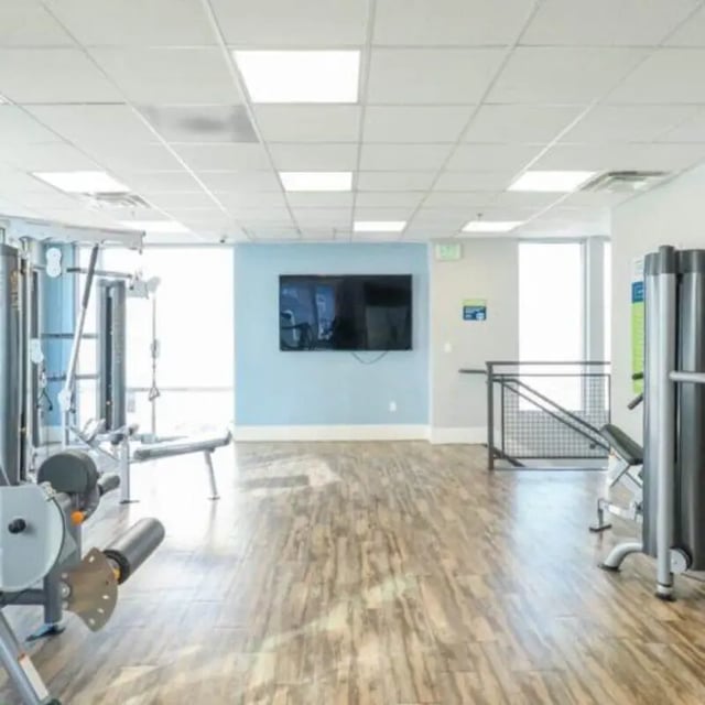 Weight machines television and wood floor gym at Promenade Place in Orem Student Accommodation