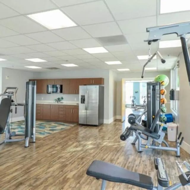 Gym equipment and kitchen area shared amenity at Promenade Place in Orem Student Accommodation