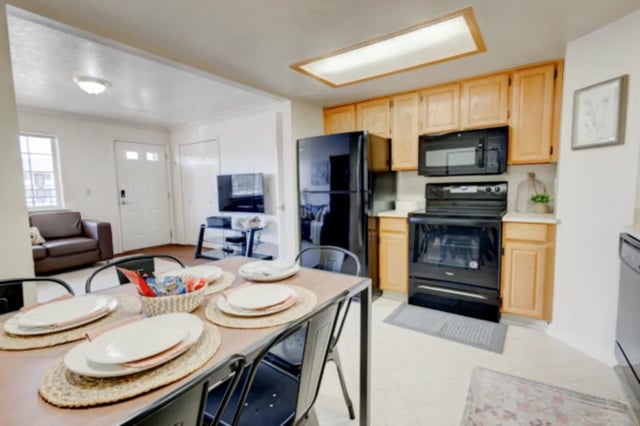Dining table with place settings and kitchen area Living room at The Colonial House in Rexburg Student Accommodation