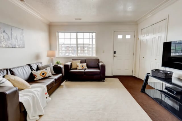 Leather couches rug window white door living room at The Colonial House in Rexburg Student Accommodation