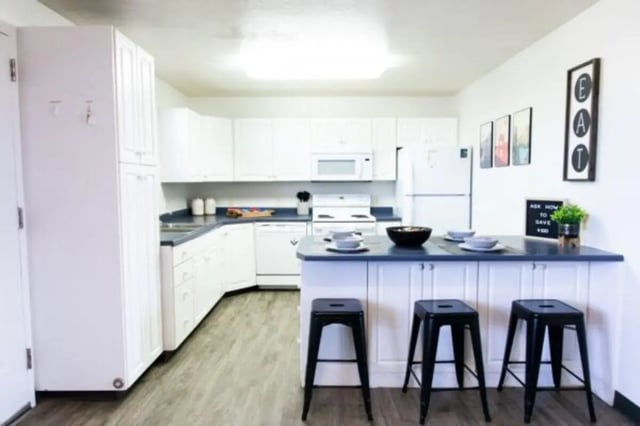 Kitchen with island white cabinets and three bar stools kitchen at Nauvoo House Apartments in Rexburg Student Accommodation