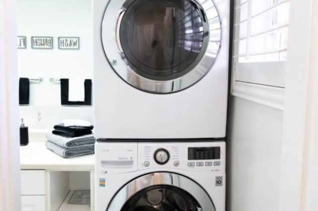 Stacked washer dryer with folded towels laundry area at Nauvoo House Apartments in Rexburg Student Accommodation