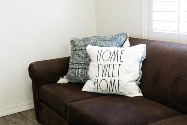 Brown couch with two decorative pillows living room at Nauvoo House Apartments in Rexburg Student Accommodation
