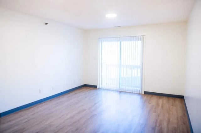 Empty room wood floor vertical blinds living room at Silvertree Communities in Muncie Student Accommodation
