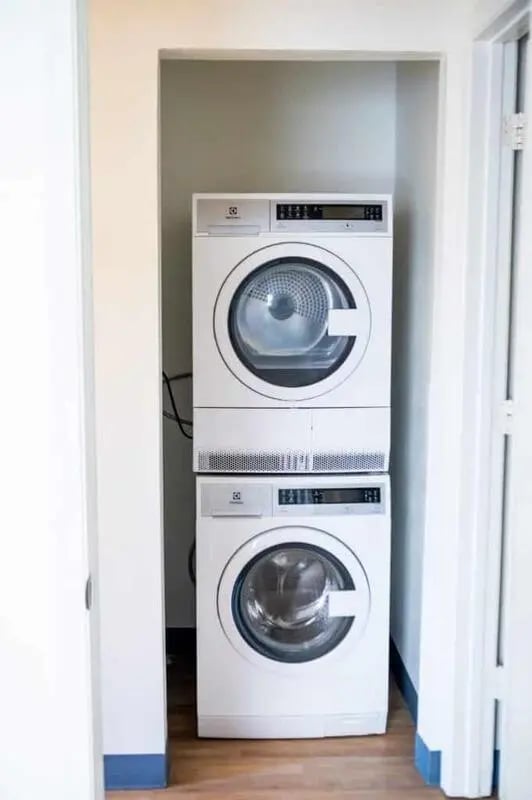Stacked white washer dryer unit laundry area at Silvertree Communities in Muncie Student Accommodation