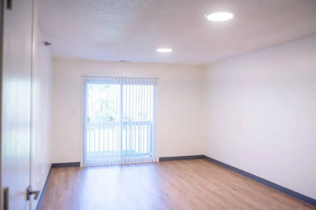 Sliding glass door with vertical blinds wooden floor living room at Silvertree Communities in Muncie Student Accommodation