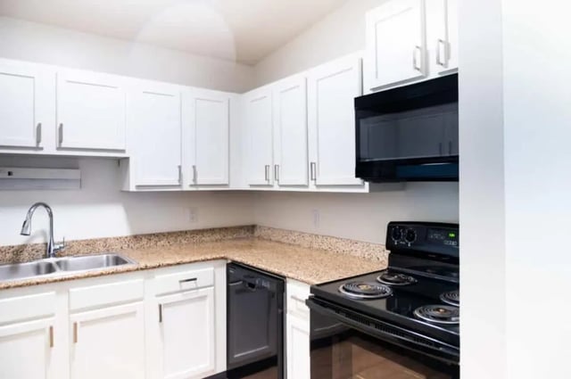 White cabinets sink microwave stove dishwasher kitchen at Silvertree Communities in Muncie Student Accommodation
