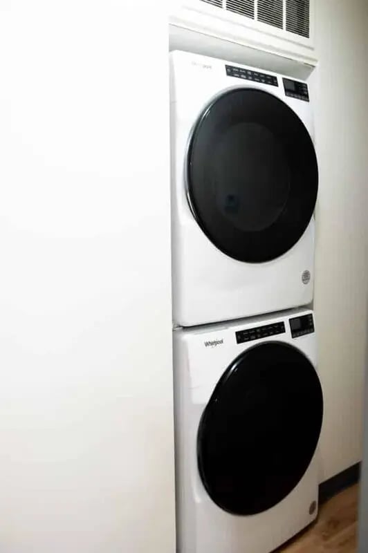 Stacked white Whirlpool washer and dryer laundry room at Silvertree Communities in Muncie Student Accommodation