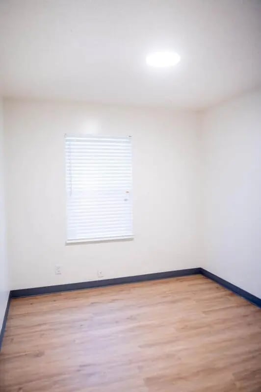 Empty room with blinds and wood floor at Silvertree Communities in Muncie Student Accommodation