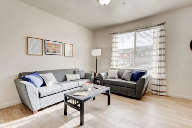 Two grey sofas coffee table framed pictures living room at The Gates in Rexburg Student Accommodation