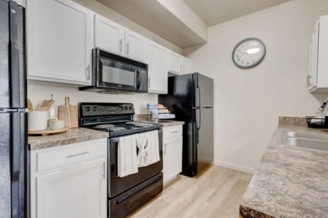 Black appliances white cabinets stone countertop kitchen at The Gates in Rexburg Student Accommodation