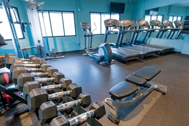 Dumbbells treadmills and workout bench gym at The Gates in East Lansing Student Accommodation