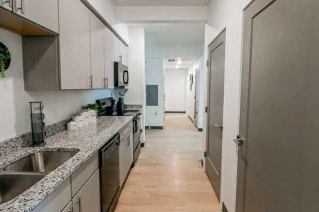 Kitchen with grey cabinets granite countertop dishwasher and hallway kitchen at The Green on Campus Drive in Orem Student Accommodation