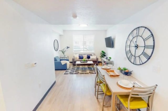 Dining table chairs clock sofa living room at The Green on Campus Drive in Orem Student Accommodation