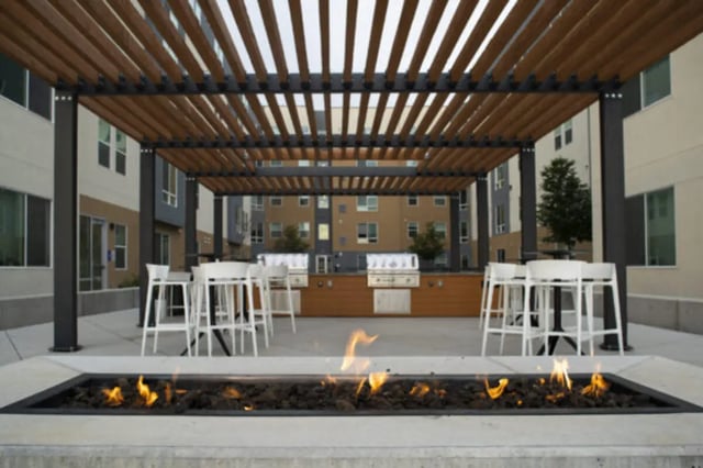 Pergola fire pit grills white tables exterior at The Green on Campus Drive in Orem Student Accommodation