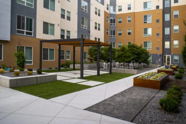 Modern building courtyard with seating and greenery exterior at The Green on Campus Drive in Orem Student Accommodation