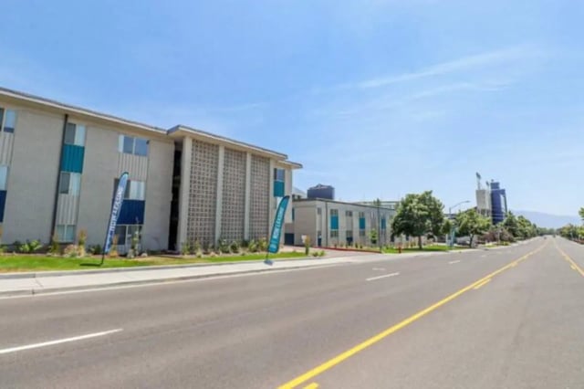 Apartment buildings with blue accents and banners exterior at Stadium150 Apartments in Provo Student Accommodation