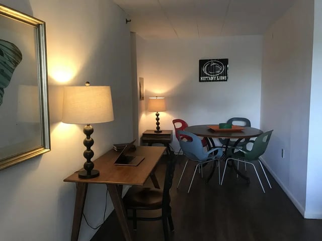 Desk lamp laptop and dining table chairs living room at Park Place Apartments in Provo Student Accommodation
