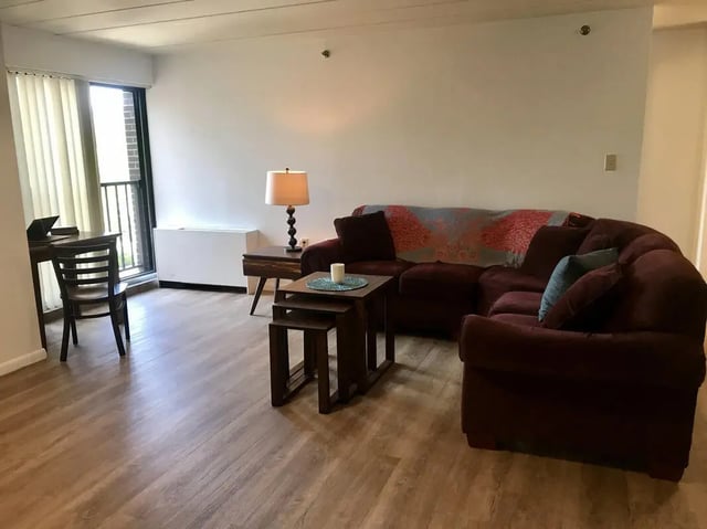 Dark sectional sofa laptop desk lamp nesting tables living room at Park Place Apartments in Provo Student Accommodation